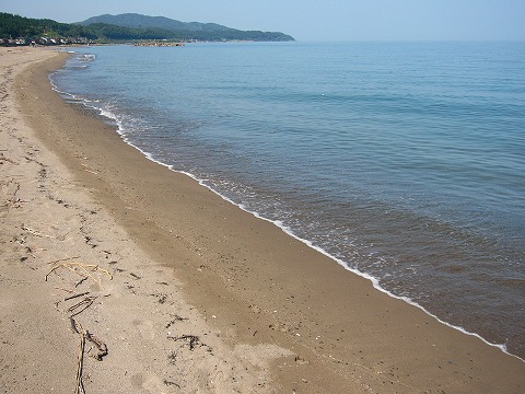 人っ子一人いない薄いクリーム色の砂浜と海
