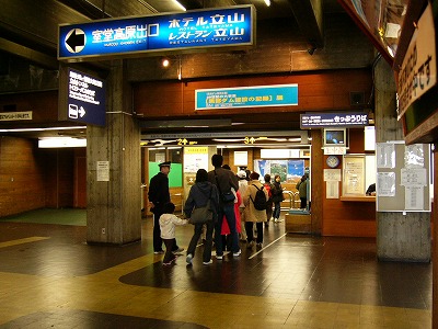 青の電灯式看板とトロリーバスの改札口