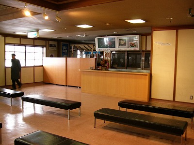 古い黒い大きな長椅子が5ぐらい見えている売店内