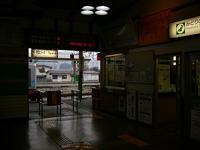 天井の高い薄暗い駅舎の中のようす。向こうには改札口が口をあけていて外が見える