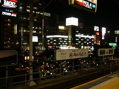 おびただしい数のタクシーと駅前の屋上の広告ネオン