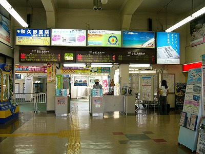 2つの有人改札口の上には大きな長方形の電照式広告灯5つとその下にLED式出発案内3つ。天井は少し高めになっている。改札口から先は緑の床になり、通路へとつながっている。