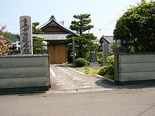 平屋の切妻の立派な寺。背の高い石碑がいくつかある。