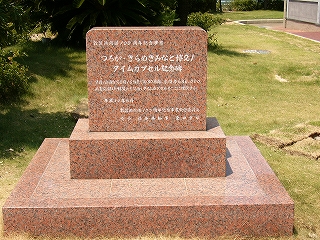 朱色と灰色と黒色の細かい斑の大理石でできた、背の低い3段重ねの碑。