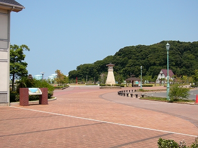 右奥の少し離れた所に緑に覆われた低い金ヶ崎が突き出ている。手前からは適度な広さのレンガの広場。左には旧敦賀港駅の建物の端がちらっと写っている。