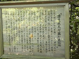 白地に黒い字の手書きの説明板。アクリル板がはめ込まれて、字の保存性をよくしている。
