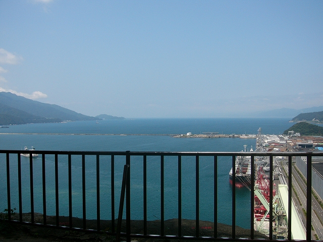 柵越しの海。右手には巨大な石炭置き場。