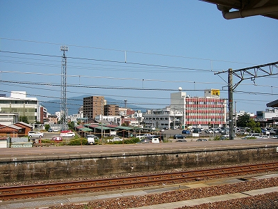 広い駐車場を挟んで向こうに中規模のビルがぱらぱらと建っている。空はきれいに晴れ渡っている。