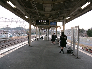 アスファルトの幅の広いホーム。ホームには椅子が置かれていない。上屋はＶ字型で、そこからフラップ式列車案内板が吊られている。