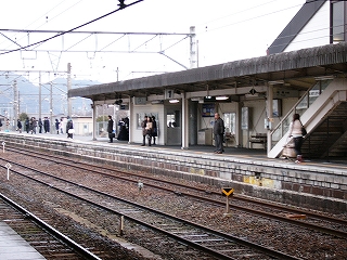 人がぱらぱらと立って待っている斜め向かいのホーム。