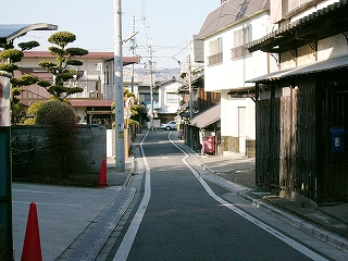 住宅が寄り添い軒を連ねる細い道。細い道ながら、両脇に白線がきちんと引かれている。