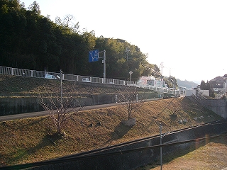 上り坂が山肌の県道に接続している。