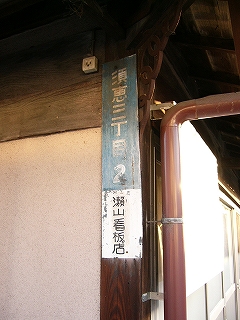 青地に白い字で町の名前が書かれた縦長の表示板。普及版とは違っている。