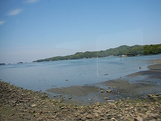 車窓から浜辺を望む。浜は尖った石が多かったり砂地になったりしている。
