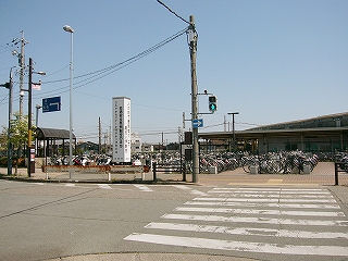 短い横断歩道の先に広々とした駐輪所。屋根が無い。