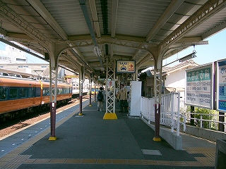 オレンジと青色の列車、広告看板など色とりどりの風景。