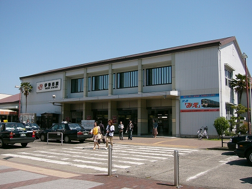 一車線分のロータリーの道路と2階建てのずんぐりした駅舎。