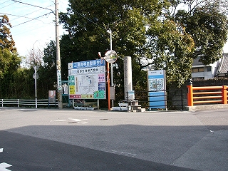 大きな住宅案内図、カーブミラー、石の円柱、緑の大木。