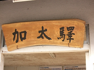 太い毛筆で「加太驛」と書かれた明るい木の厚い天然木の看板。