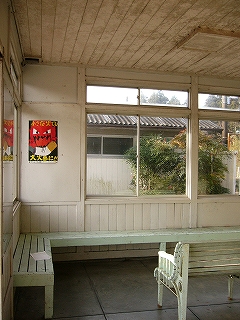 駅舎内の隅のようす。長椅子が壁に沿って取り付けられ、壁の隅で直角に折れて続いている。。