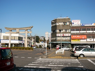 目の前に短い横断歩道。奥のほう「坂本屋旅館」という看板のかかるかなり古びた4階建ての建物。左手奥には巨大の鳥居。