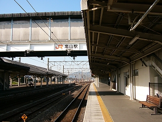 右手にホームの波板の屋根、左手上方に横たわる跨線橋を見て。