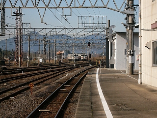 右下に太い白線を引いた青空の下の古いコンクリートのホーム、左手ずっと向こうには広い停車場があり、架線を支える鉄骨の梁が幾重にもこだましている。