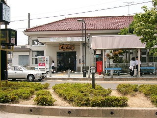 白い壁と紅色の瓦葺の駅舎。