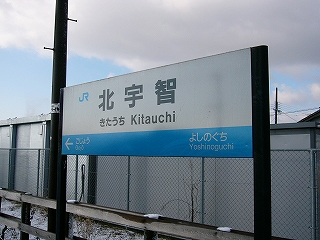 ホームに二本足で立つ駅名標。