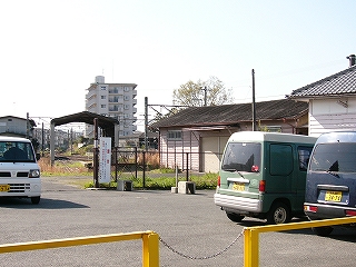 駅舎の横に付随しているシャッターの下りた自動車のためのような車庫。建物の高さは駅舎よりも低い。