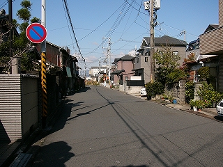 1.5車線の住宅街の道。両脇には新しい感じの家々も立ち並ぶ。