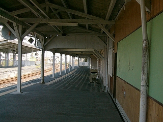 上屋の下にて。右の壁には薄緑色のゴムを敷いた横に長い掲示板が取り付けられている。左は線路内で光が上屋の中に差し込んでいる。