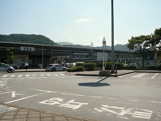 左手少し遠くに駅舎を見ながら、ロータリー中央部に作られた2台のバススペースを見て。バススペースの周りは緑地帯になっている。