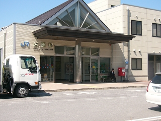 薄く落ち着いた色の真新しい駅舎。屋根は大きな切妻となっていて、その部分はガラスになっている。