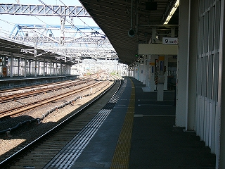 伸び行く下り線ホームの行先を見つめて。左向こうの上り線ホームも上屋のない明るいところまで伸びている。