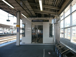 つやのある白い壁とステンレスの枠の自動扉の待合室。