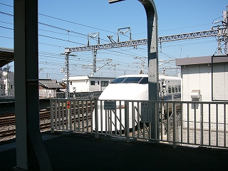 ホームの端の柵から見える新幹線の先頭車。