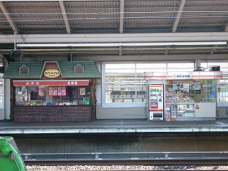 向かいのホームお店の様子。左にレンガの壁と緑の屋根の少し凝った「新幹線グルメ」という弁当屋、右手にキオスク。