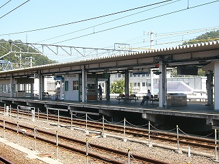 厚みのある波板の上屋を持つ新しい感じのさっぱりしたホーム。手前には3線の線路内がある。