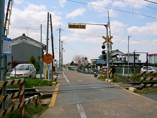 踏み切りの向こうに畑。