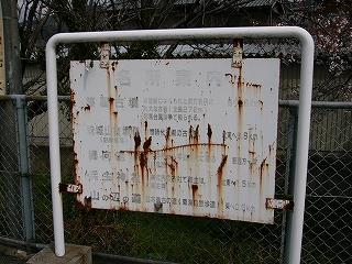 鉄板製のためぼろぼろになり、ほとんど黒い字が見えなくなった白い名所案内。