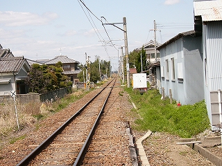両脇に少し余裕を持たせて単線が民家をまっすぐ走り抜いている。