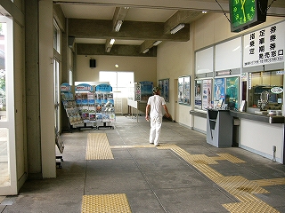 縦長の空間。天井はコンクリートが格子状に浮き立っていて、桟に囲まれたところはクリーム色で塗られている。この空間のずっと奥にはパンフレット陳列棚が置かれている。