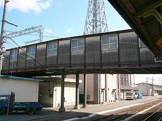 すすけた波板で覆われた連絡通路。