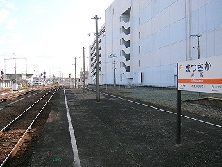 右手に百貨店の建物の壁。伸び行く線路内。