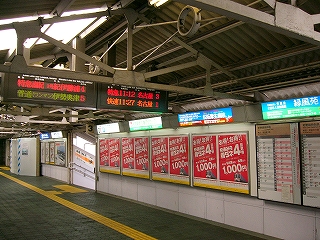 屋根の始まりの辺と壁の終わりの辺りに横長の電照式広告看板が並ぶ。