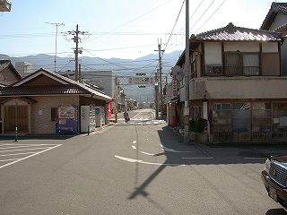 駅前広場の一部と、そこからまっすぐに伸びる道の両脇に立つ民家。広場からまっすぐに伸びる道はすぐに国道と交差している。