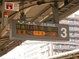屋根から吊られたねずみ色の枠を持つLED式行き先案内。2段になっていて、下段に列車が今どこにいるか表示される。
