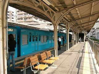 ホームの屋根の下から水色の列車の中ほどを見て。