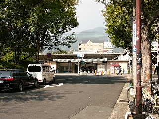 両脇に街路樹、真中の少し遠い所に平屋の改札口。